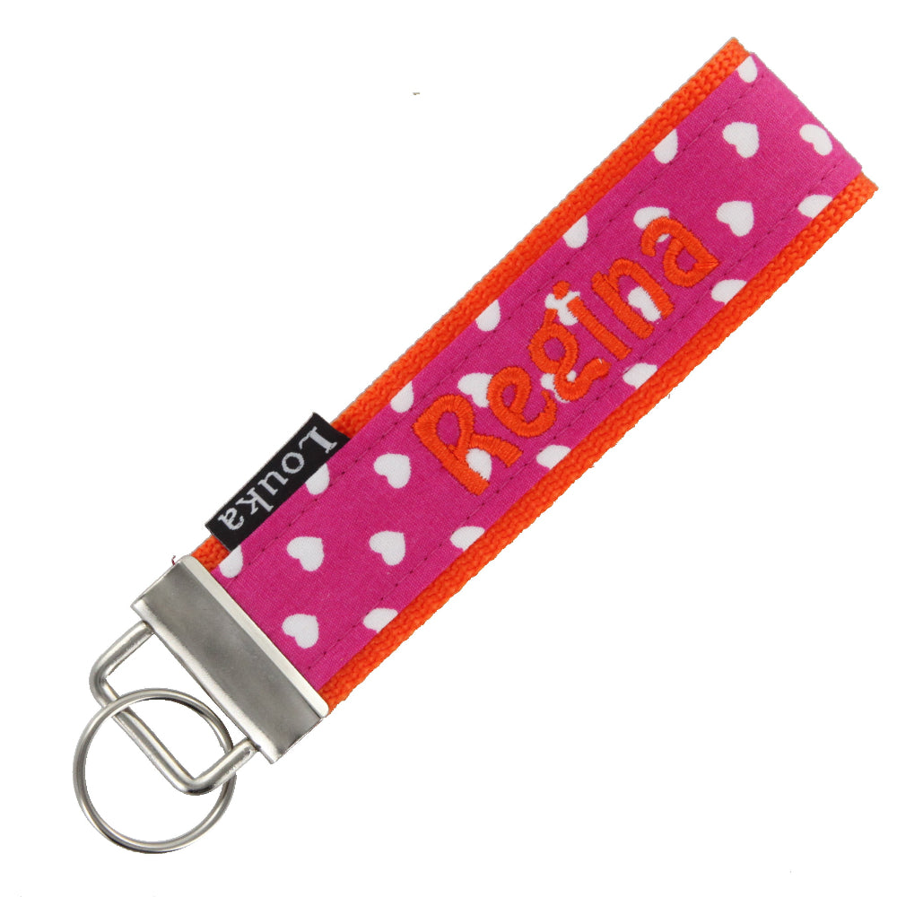 Handgemaakte Louka pols sleutelhanger met fuchsia hartjesprint, personaliseerbaar met naam en hardware, formaat 13×3 cm.